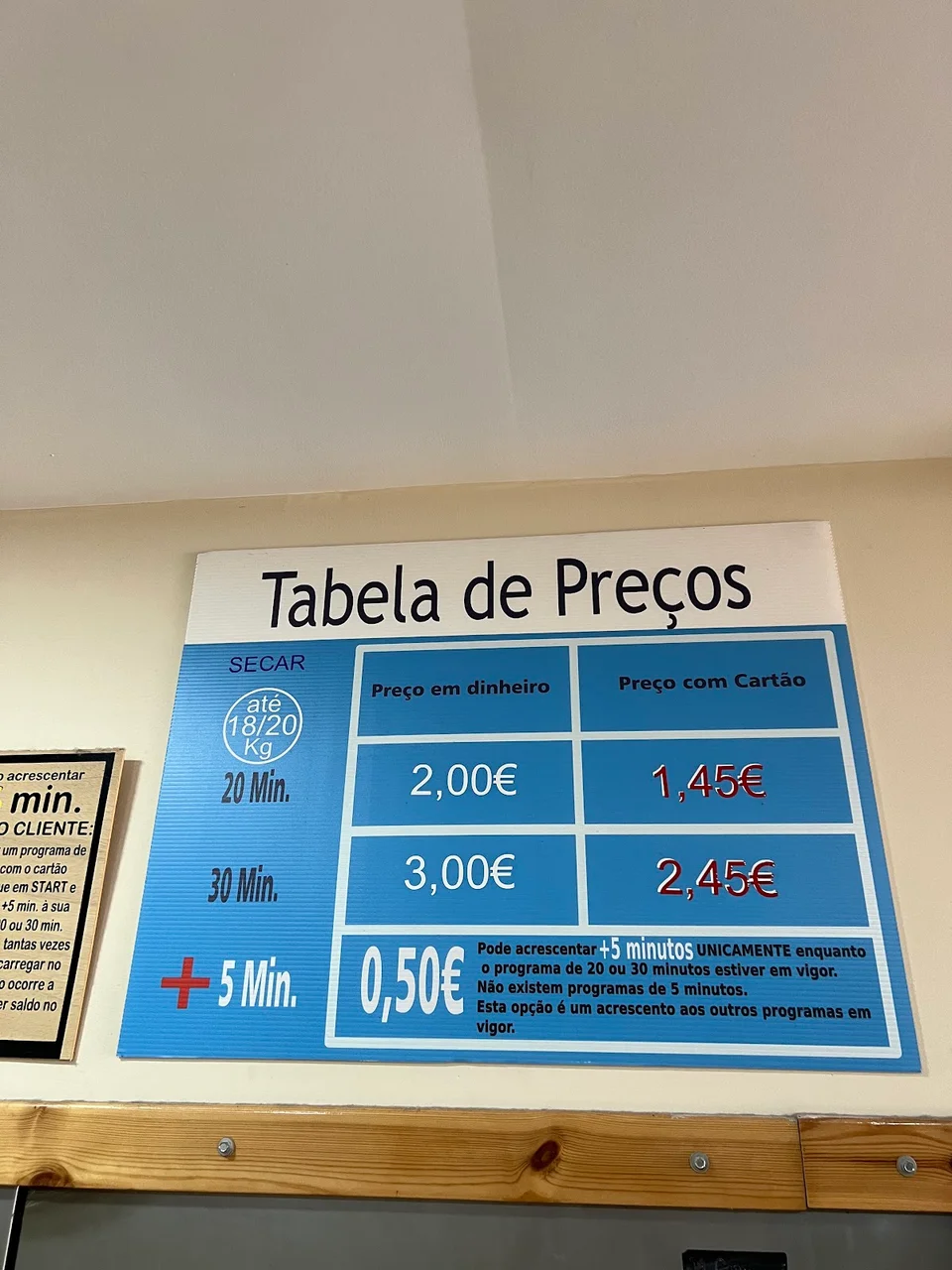 Tabela de preços de secagem afixada na parede da lavandaria